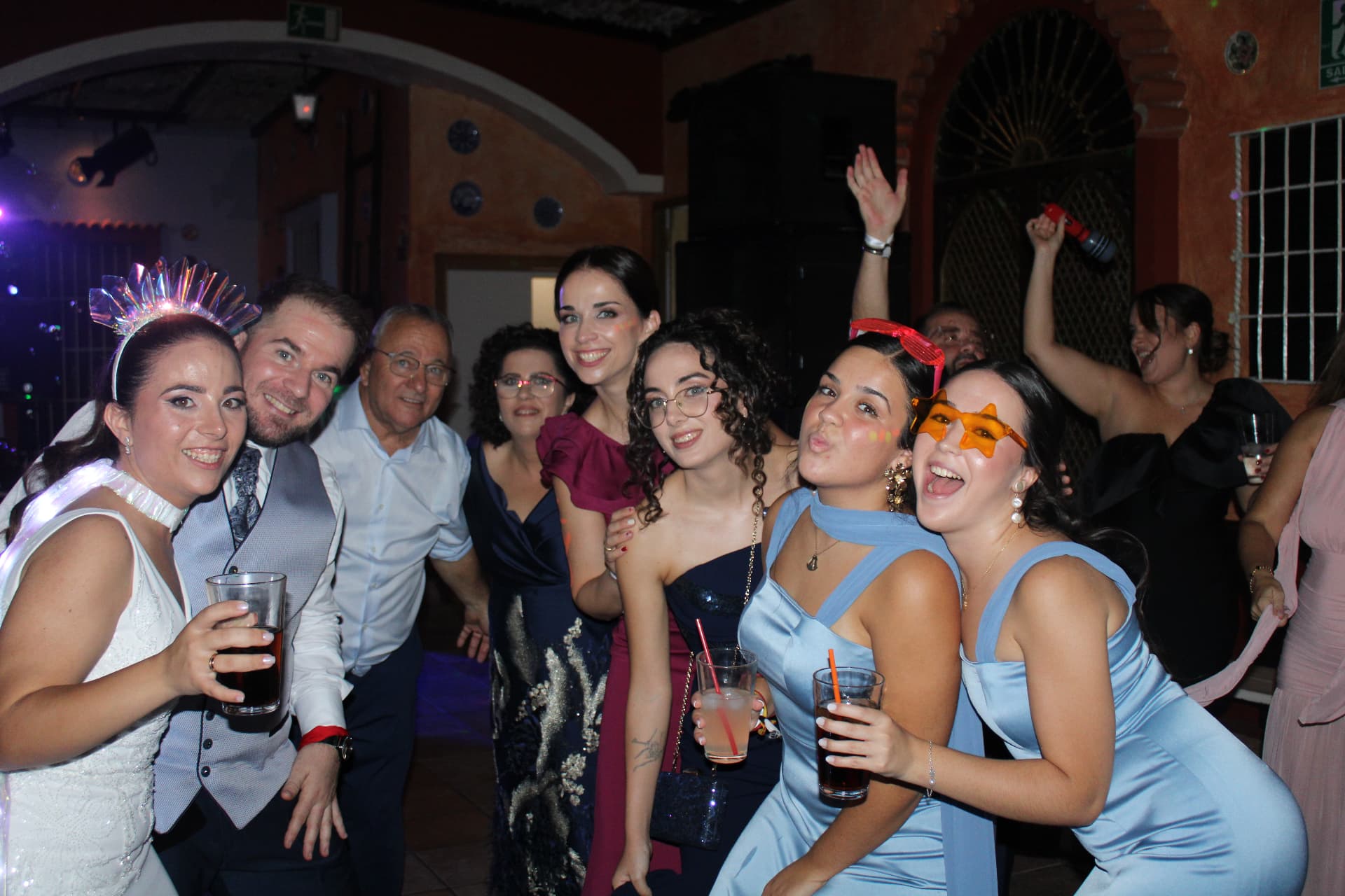 Novios y amigas con gafas de fiesta durante la barra libre de una boda