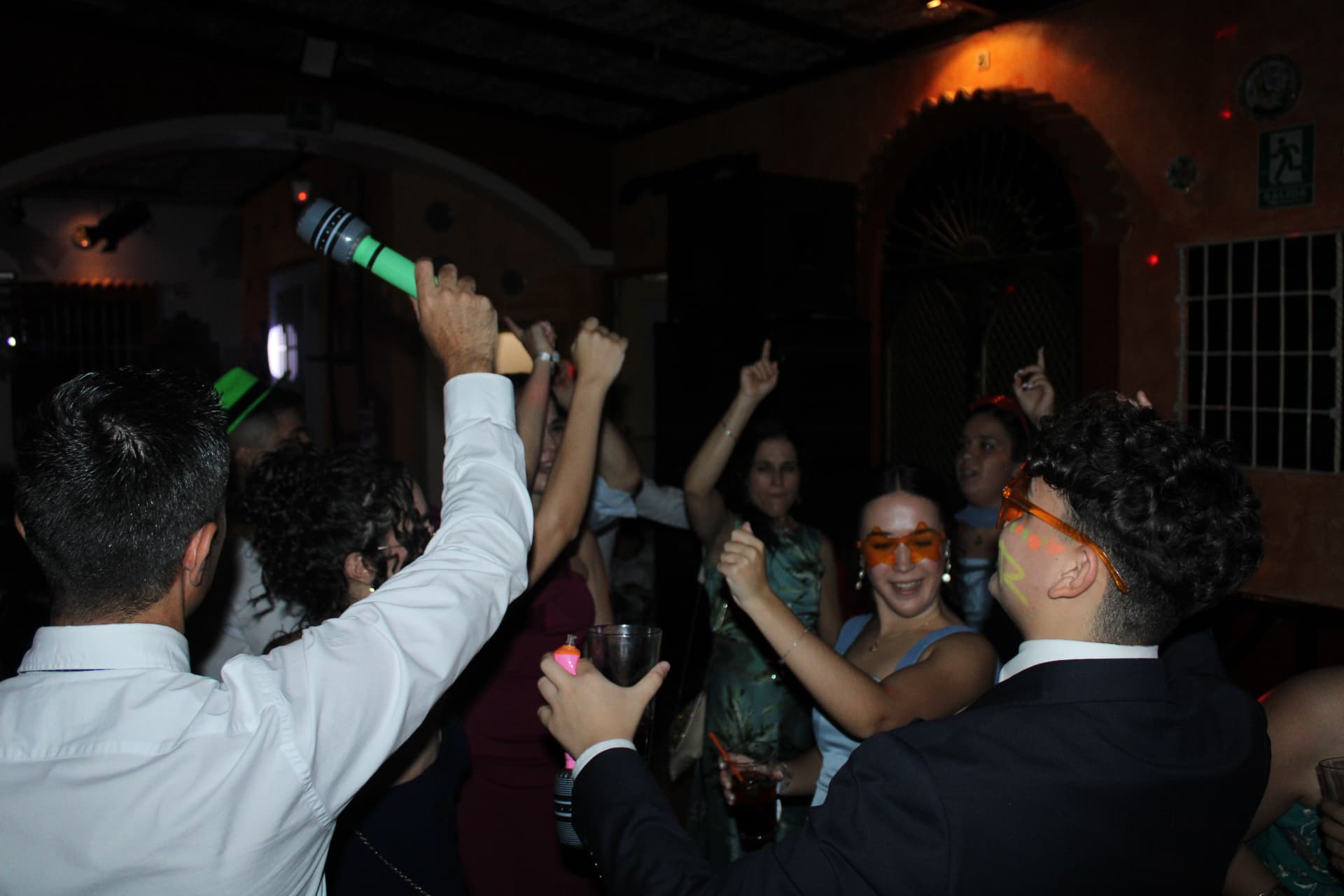 Invitados bailando con micrófonos de juguete y gafas de fiesta